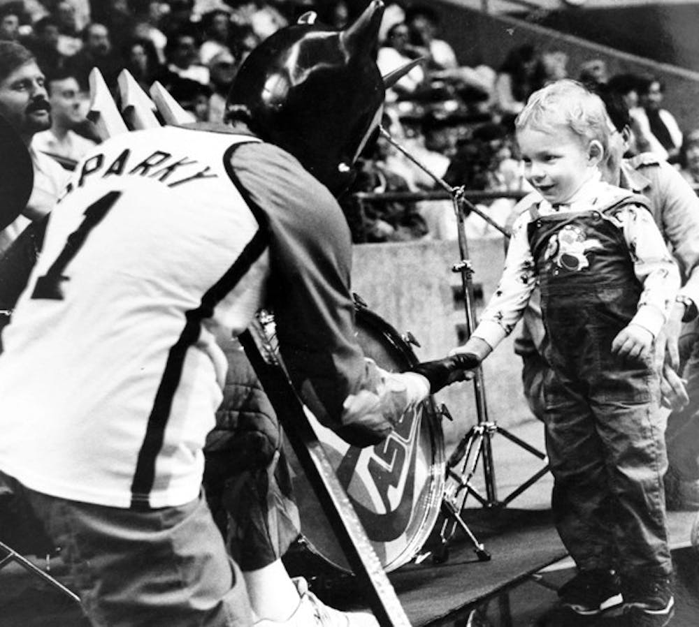 LITTLE FAN: Sparky greets a young ASU admirer at a basketball game in 1988. (Photo by Susan Schuman)
