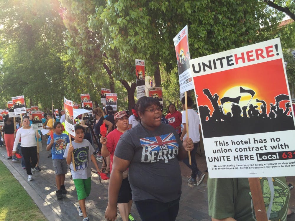 Community supporters march in front of the Tempe Mission Palms hotel on June 24 to demand workers' right to a fair process, which would grant employees protection from workplace mistreatment.