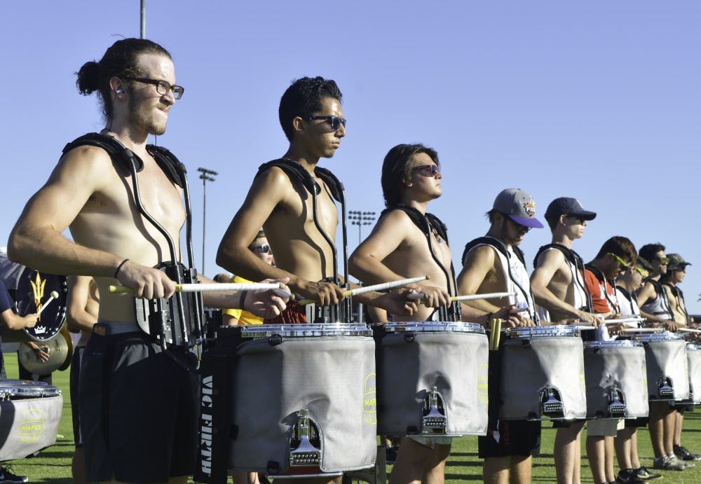 Sophomore Dustin Endicott, left, and freshman Sabeel Kaurram lead a drum line at the band's practice on Friday, Sept. 9, 2016.