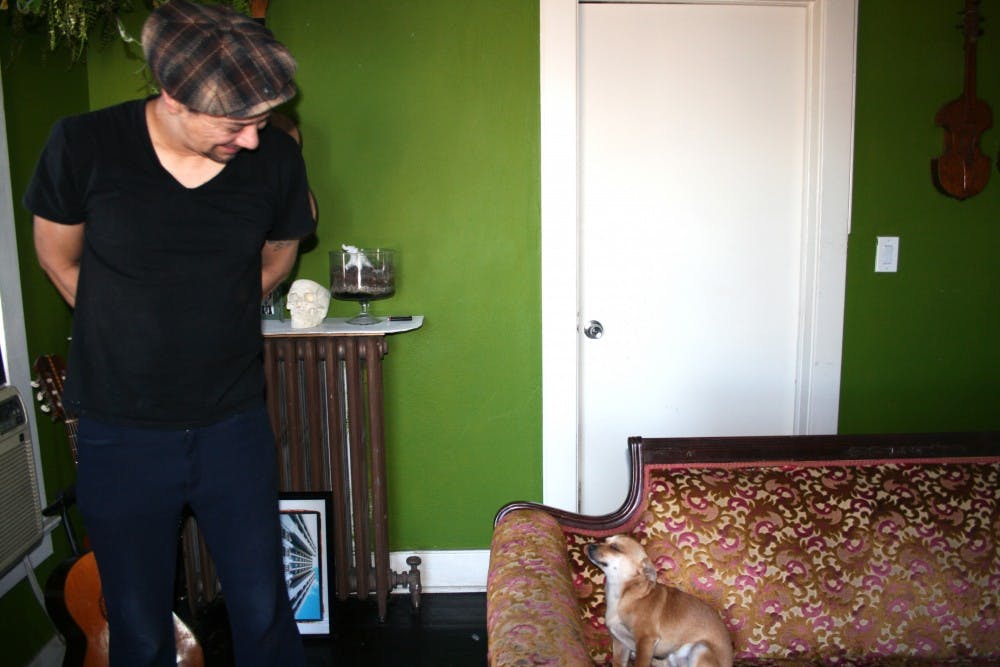 Artist Tato Caraveo exhanges a glance with his puppy, Duke, in his downtown Phoenix apartment on Monday, Jan. 11, 2016.
