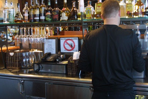 PF BANG: A sign prohibiting weapons sits behind a bar at P.F Chang’s on Mill Ave. The restaurant like many others in the Mill Ave district is against allowing any form of dangerous weapon in to their facility. (Photo by Serwaa Adu-Tutu)