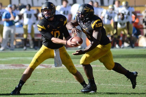Redshirt sophomore quarterback Taylor Kelly hands the ball off to senior running back Cameron Marshall during the Sun Devils’ 45-43 loss to UCLA on Oct. 27. (Photo by Aaron Lavinsky)
