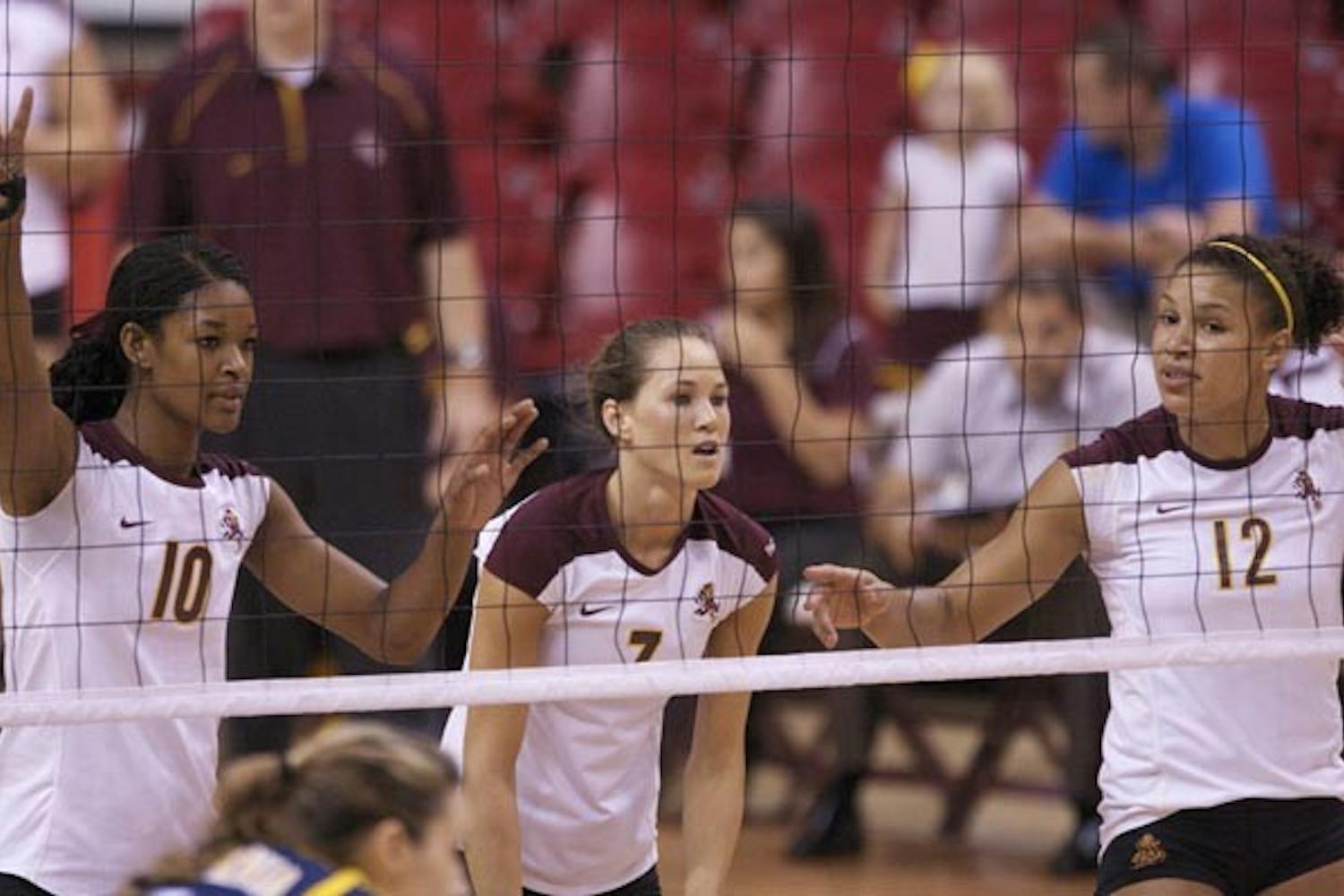 TALENTED TRIO: Sophomore outside hitter Erica Wilson, junior setter Cat Highmark and senior outside hitter Sarah Reaves adjust between sets during a recent tournament. ASU looks to collect its first Pac-10 win in Washington this weekend. (Photo by Scott Stuk)