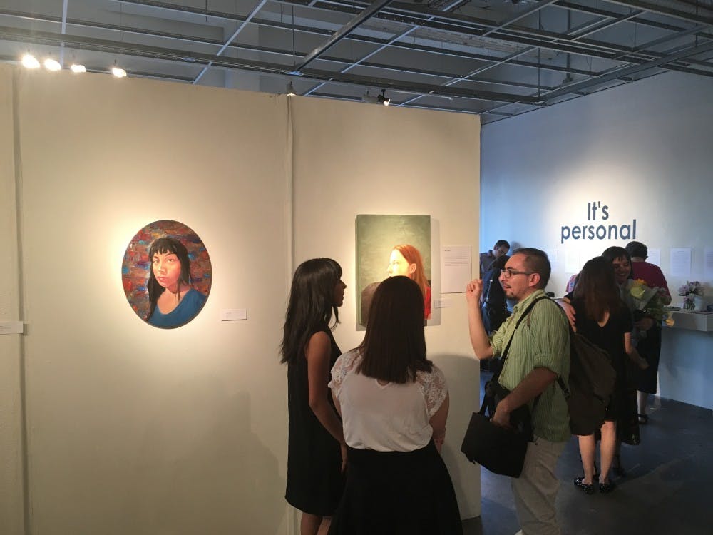 Gallery visitors admire artwork at the gallery opening for "It's Personal" on Tuesday, April 25, 2017.&nbsp;