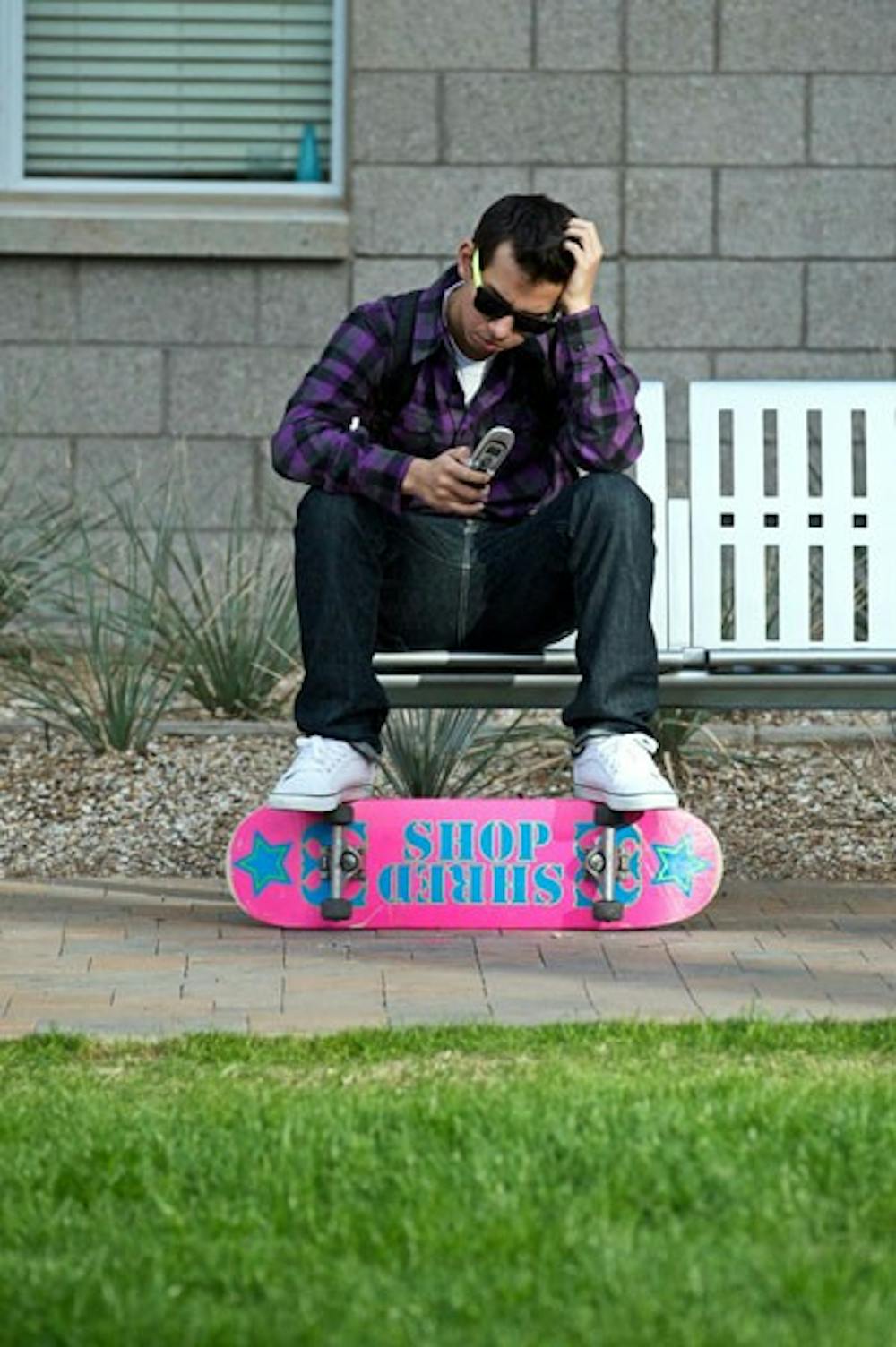 HIGH TECH: An ASU student enjoys the sun as he texts on his phone near the Barrett front lawn. ASU has recently partnered with Japanese universities for the ongoing development of Consumer Electronic Devices, such as cell phones. (Photo by Michael Arellano)