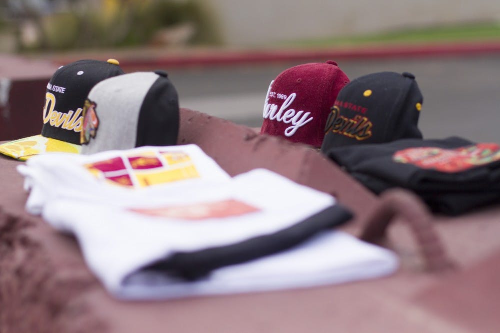 Digital culture sophomore Cameron Benally's modified clothing sits in front of Sun Devil Stadium. Benally has redesigned ASU sporting gear using his own art and placing them on the hats and shirts he has purchased. (Photo by Thomas Hawthorne)