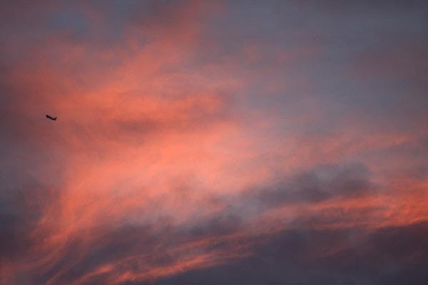 FLY BY: The weekend rain makes for a beautiful sunset as a plane flies through the clouds over ASU's Tempe campus.