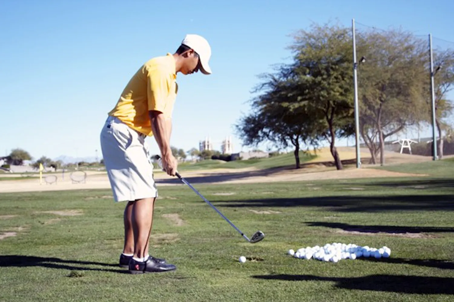LOOKING DOWN: ASU junior Jin Song concentrates on one of his many practice balls prior to a swing in practice last January. The men’s golf team finished 14th out of 15 teams against top-tier schools in the Illini Invitational over the weekend. (Photo by Lisa Bartoli)