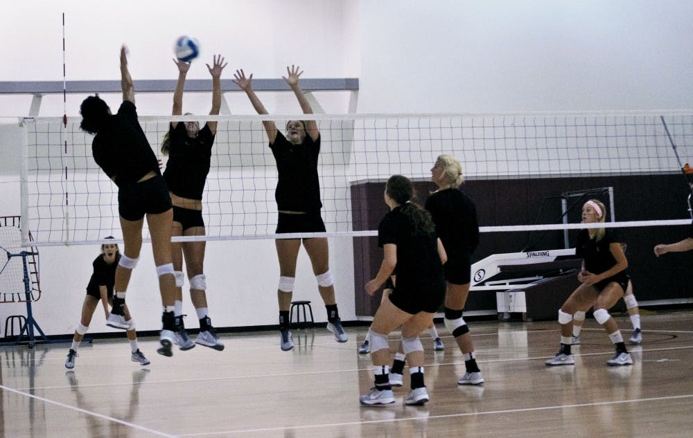 The ASU women’s Volleyball team practices setting up a perfect play for one of their teammates to spike the ball on the opposing side.  The opposing side is practicing blocking such plays. (Photo by Katherine Dunphy)