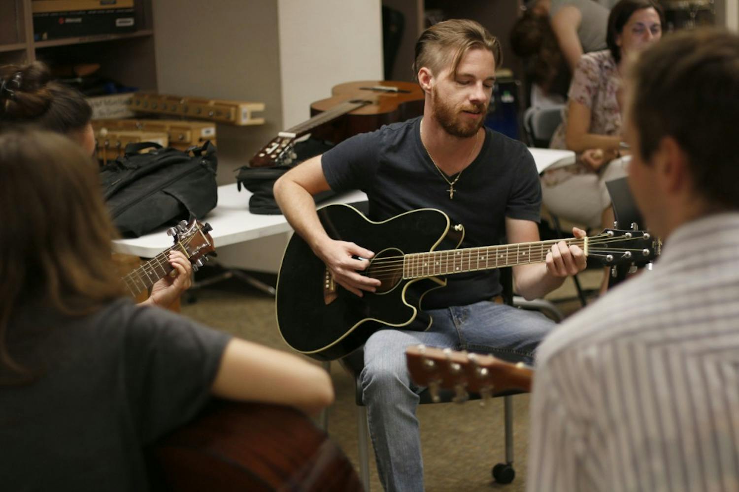 Nick Pompliano, who has been playing guitar for 10 years, teaches leads a group at the Guitar for Vets meeting on Oct. 14, 2016, in Tempe, Arizona. 