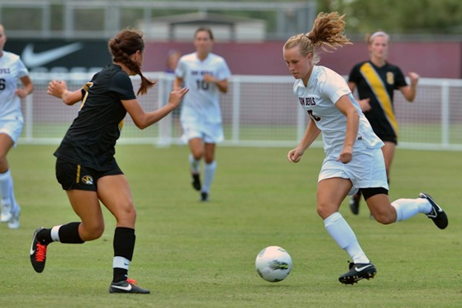 DOWN THE MIDDLE: Sophomore midfielder Taylor McCarter dribbles between two Washington defenders during Sunday's game. Despite a 1-0 loss, ASU coach Kevin Boyd said the team played its best possession game all year. (Photo Courtesy of Steve Rodriguez)