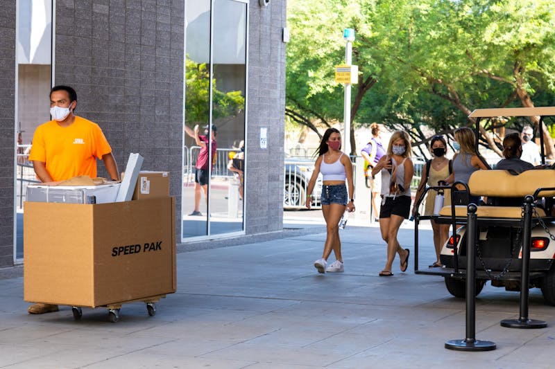 A volunteer pushes a cart of student belongings on Saturday, Aug. 15, 2020, on the ASU Tempe Campus.