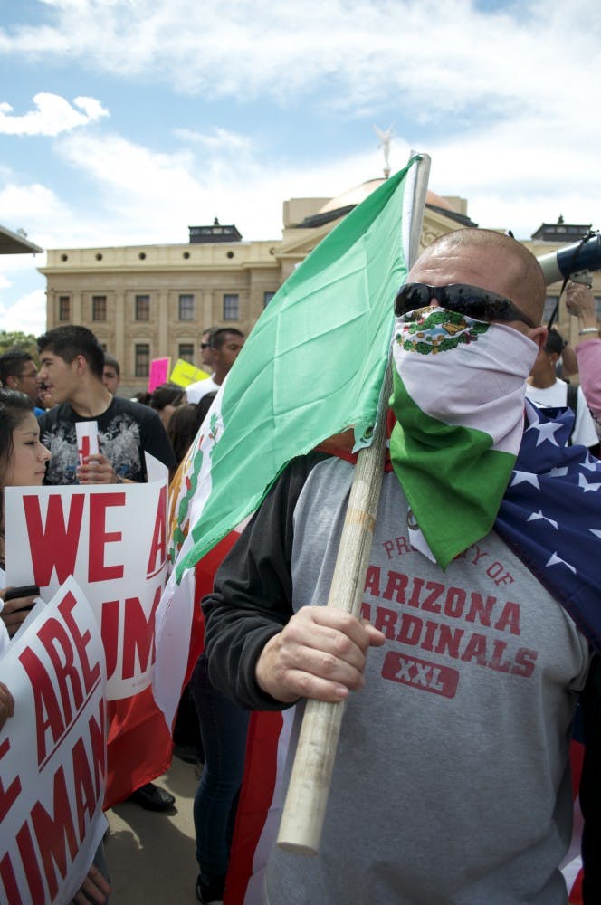 Marcell Chavez, of Phoenix, wore both an American flag and a Mexican flag to the rally to protest SB 1070, the immigration bill signed by Gov. Brewer Friday afternoon. (MOLLY SMITH | THE STATE PRESS)