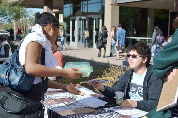 ASU students stop by tables set up on Taylor Mall at the Downtown campus Tuesday to learn about local art venues. (Photo by Brittany Lea)