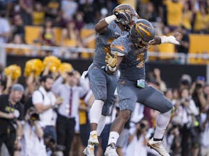Sophomore linebacker Christian Sam, right, celebrates with freshman linebacker Khaylan Thomas after returning an interception for a touchdown during a game at Sun Devil Stadium in Tempe, Ariz., on Saturday, Nov. 21, 2015. The ASU Sun Devils took down the UA Wildcats, 52-36. 