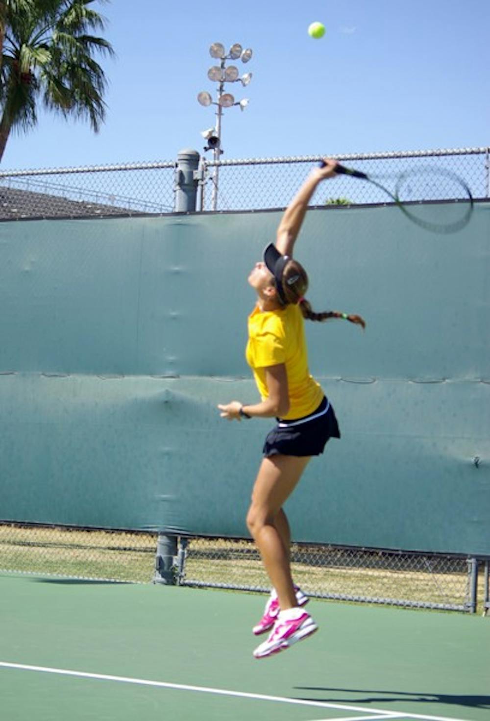 SWING OF THINGS: ASU sophomore Jacqueline Cako stretches for a serve during a match against UC Irvine in April. Cako is ranked No. 11 in the country to start the season. (Photo by Nathan Meacham)