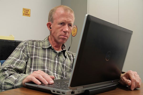 Social work freshman Mark Ledingham listens to the audio version of the novel “World War Z” for his class during his day off Friday afternoon at Discovery Hall. Diagnosed with brain cancer in 1977, Ledingham beat the disease but became legally blind as a result. (Photo by Shawn Raymundo)