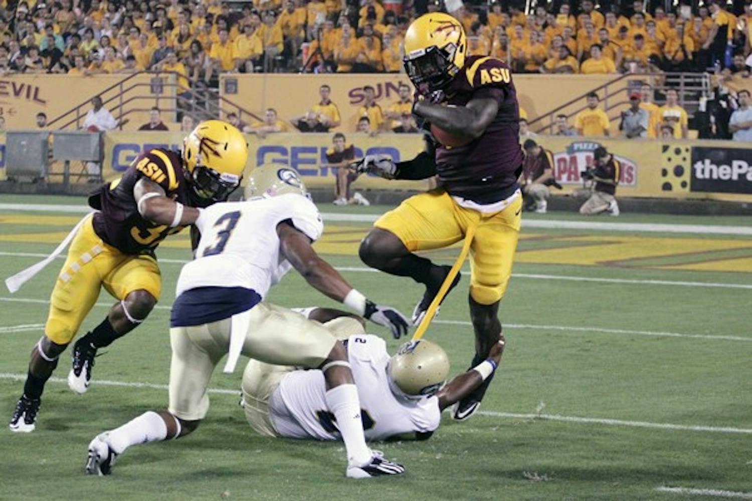STRONG OUT WIDE: ASU senior wide receiver Mike Willie tries to jump over a pair of UC Davis defenders during the Sun Devils’ victory on Sept. 1. ASU’s depth at wide receiver could be a key factor during Saturday’s matchup against Illinois. (Photo by Beth Easterbrook)