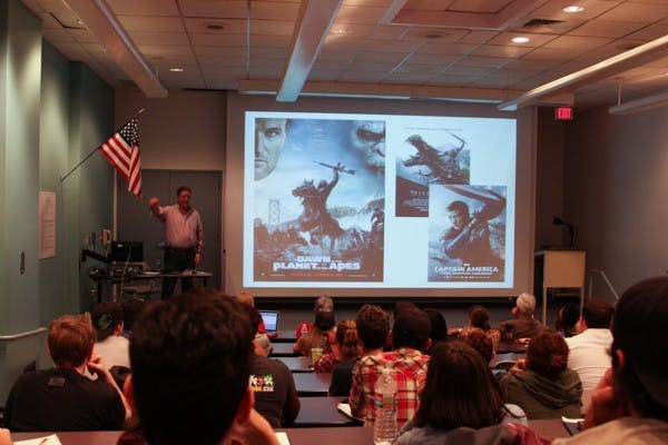 Bunnygraph Entertainment CEO John D. Heinsen shows the similarities between Hollywood movie posters during his presentation on transmedia at the Durham Language and Literature building on Tuesday, Oct. 21st. (Photo by Daniel Kwon)