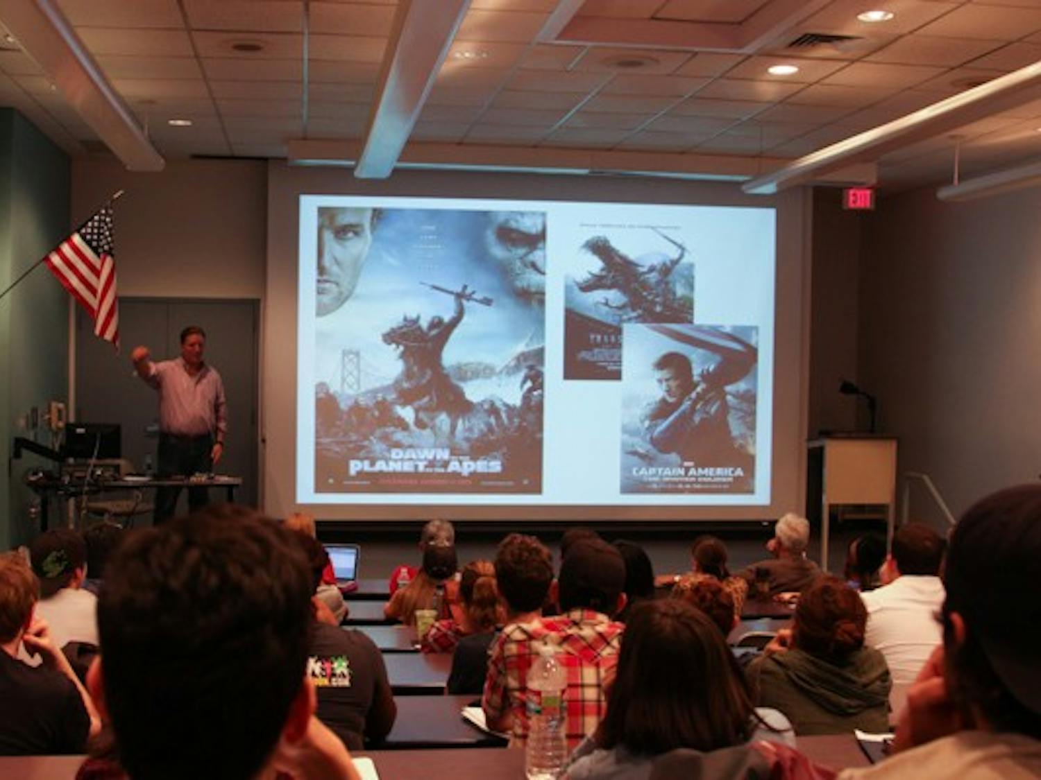 Bunnygraph Entertainment CEO John D. Heinsen shows the similarities between Hollywood movie posters during his presentation on transmedia at the Durham Language and Literature building on Tuesday, Oct. 21st. (Photo by Daniel Kwon)