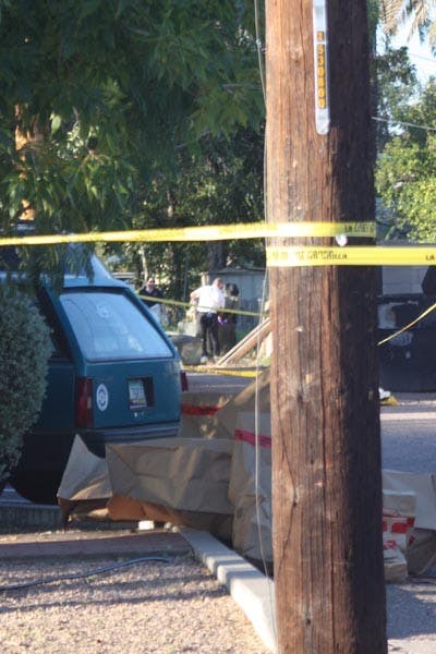 Evidence bags lie on the ground while officers look for more evidence in an alley near 10th and Ash where the body of a man was discovered earlier today. (Photo by Jessica Weisel)
