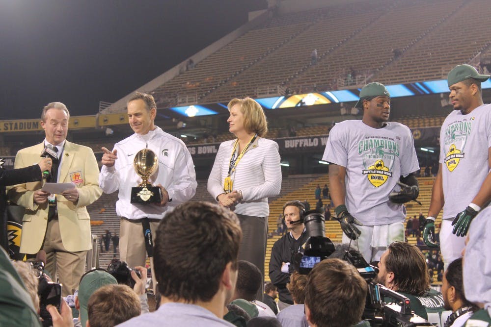 MSU coach Mark Dantonio accepts the Buffalo Wild Wings Bowl trophy. Dantonio's Spartans were able to overcome a dismal first half to win the bowl in Tempe. 