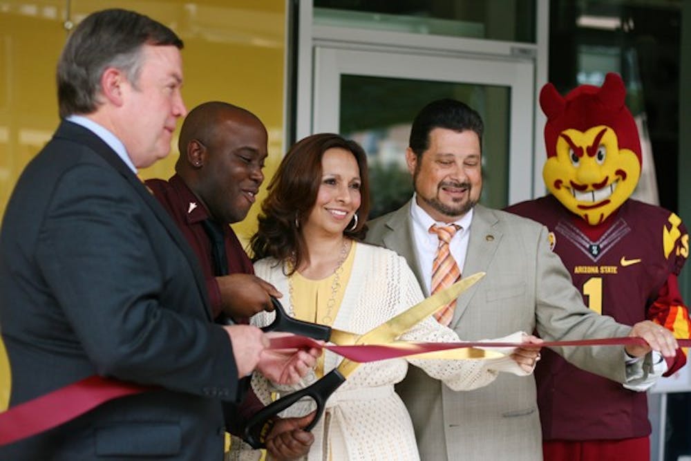 Building Operations Manager Marcus Jones cuts a maroon ribbon outside of the Student Center at the Downtown Phoenix campus to officiate its grand opening Tuesday afternoon. Jason, is accompanied by President Michael Crow, Dean of Students Georgeana Montoya, Phoenix Councilman Michael Nowakowski and Sparky. (Photo by Perla Farias)