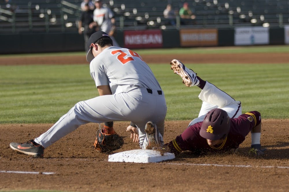 ASU freshman outfielder Hunter Bishop (24) dives back to first base after the Beavers pitcher threw it to the first baseman during game two of a baseball series against the Oregon State Beavers at Phoenix Municipal Stadium in Phoenix on Friday, March 17, 2017. ASU lost 10-1. 