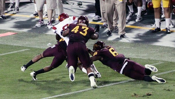 HELPING OUT: Sophomore defensive end Davon Coleman helps tackle a USC ball carrier during the Sun Devils’ 43-22 win over the Trojans on Saturday. Coleman is emerging as a force on defense this season since transferring from Fort Scott Community College in Kansas. (Photo by Beth Easterbrook)