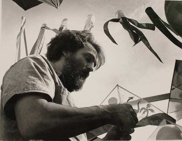 In this State Press archived photo, Harry Lochman of West Wind Kites, demonstrates how to attach the string to a kite at the Mill Avenue Festival of the Arts.  (Photo by Tamara Wofford)