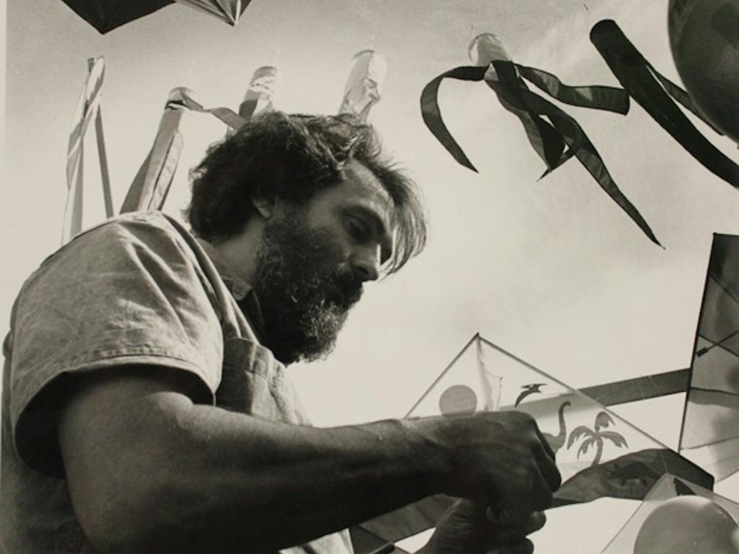 In this State Press archived photo, Harry Lochman of West Wind Kites, demonstrates how to attach the string to a kite at the Mill Avenue Festival of the Arts.  (Photo by Tamara Wofford)