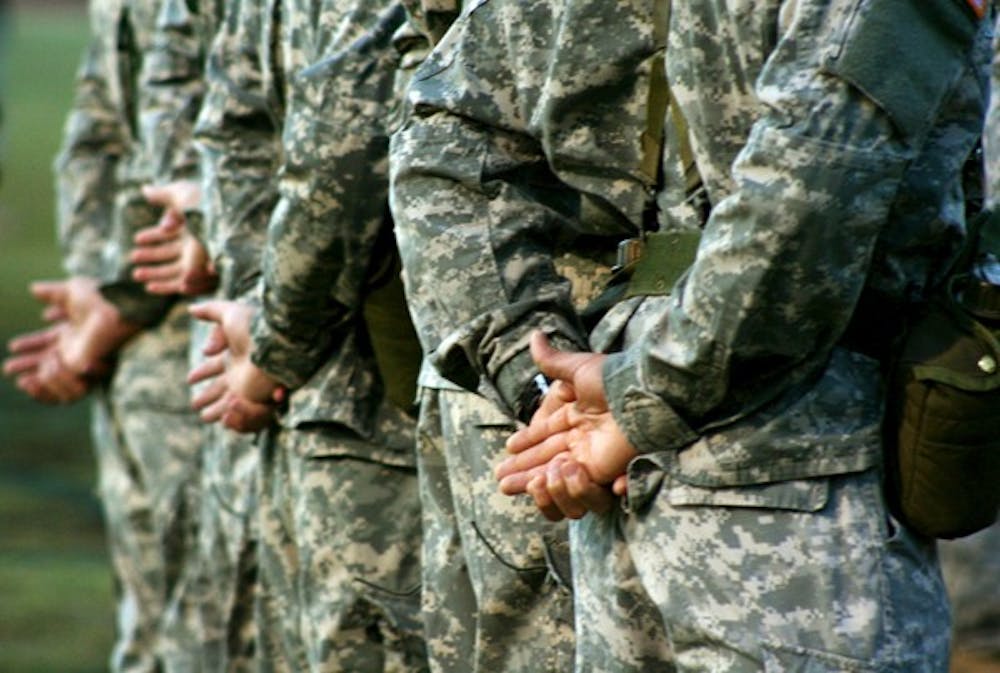 RISE AND SHINE: ASU ROTC cadets stand at attention during a sunrise drill on the Tempe campus SRC field Tuesday morning. (Photo by Lisa Bartoli)