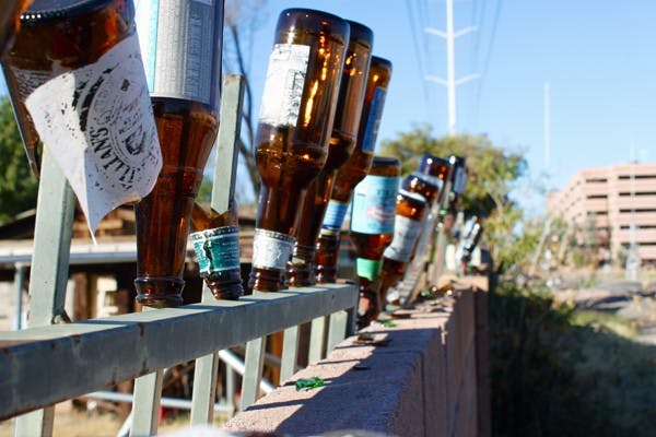 BOTTOMS UP: Bottles find a second life as decorations on the top of a fence a few blocks from the Tempe campus. (Photo by Rosie Gochnour)