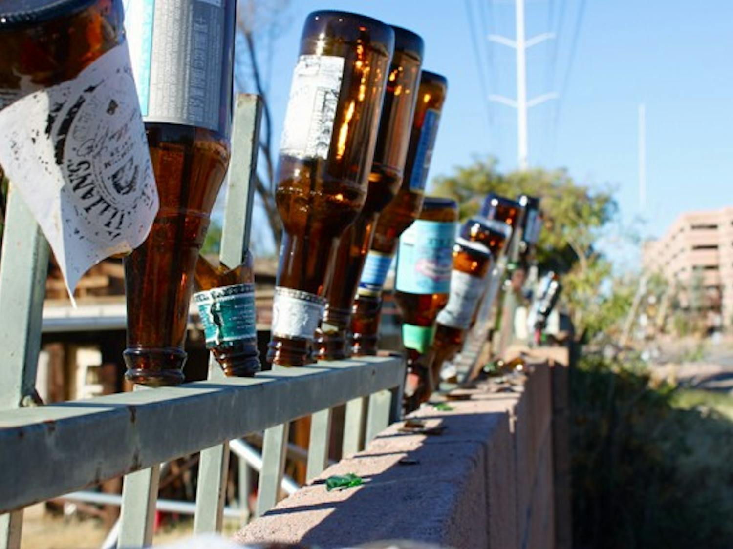 BOTTOMS UP: Bottles find a second life as decorations on the top of a fence a few blocks from the Tempe campus. (Photo by Rosie Gochnour)