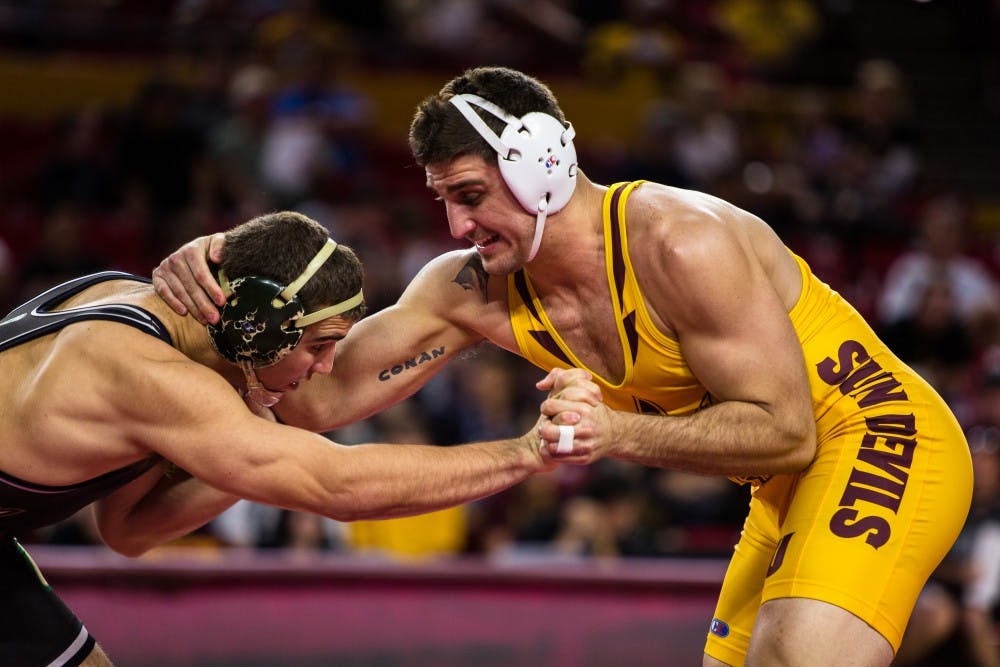 ASU redshirt junior Josh DaSilveira grapples with Cal Poly sophomore J.T. Goodwin during the 197-pound weight division match at Wells Fargo Arena on Feb. 16, 2015. DaSilveira would earn the victory and the Sun Devils would win in dominating fashion beating the Mustangs 30-9. (Daniel Kwon/The State Press)