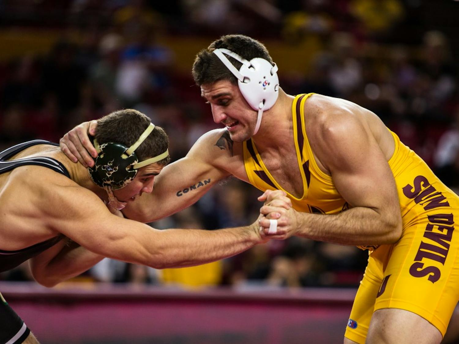 ASU redshirt junior Josh DaSilveira grapples with Cal Poly sophomore J.T. Goodwin during the 197-pound weight division match at Wells Fargo Arena on Feb. 16, 2015. DaSilveira would earn the victory and the Sun Devils would win in dominating fashion beating the Mustangs 30-9. (Daniel Kwon/The State Press)