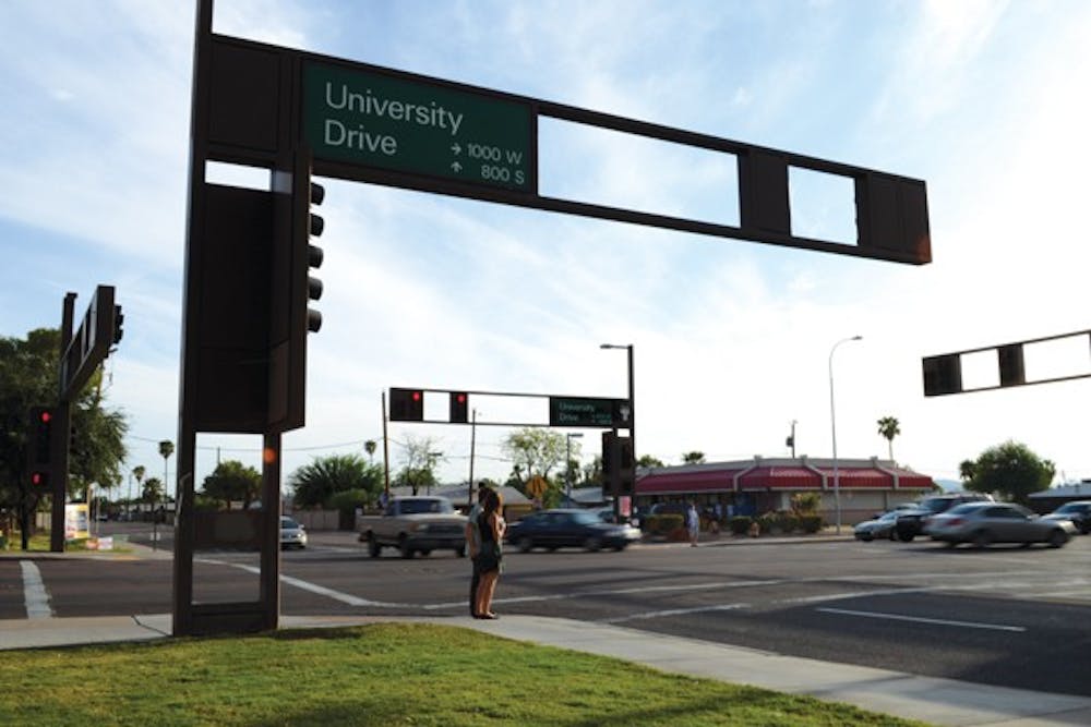 Pedestrians wait to cross the street on the corner of University and Hardy drives.  The City of Tempe is planning to update University Drive from Ash Avenue to Priest Drive with new streetscaping, bike lanes and two new crosswalks. (Photo by Kurtis Semph)