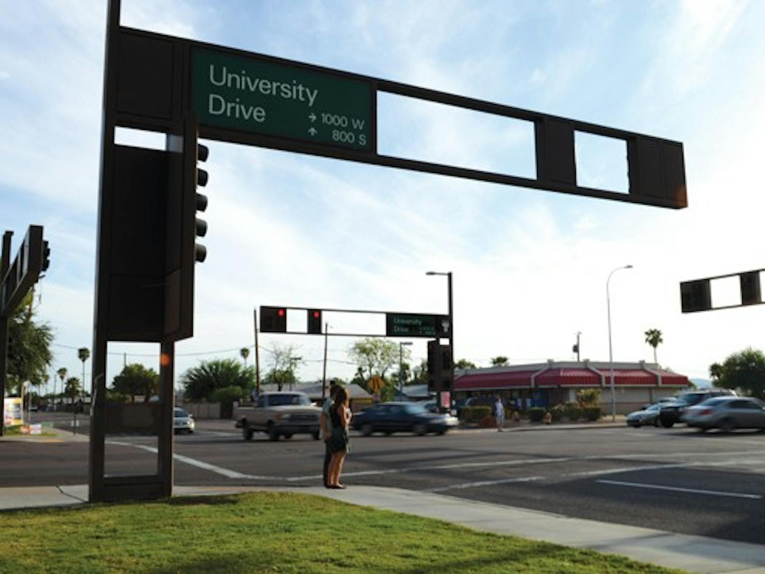 Pedestrians wait to cross the street on the corner of University and Hardy drives.  The City of Tempe is planning to update University Drive from Ash Avenue to Priest Drive with new streetscaping, bike lanes and two new crosswalks. (Photo by Kurtis Semph)