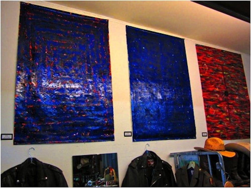 Three of Kee Gan’s paintings, for sale at the Blue Jean Buyer. Photo by Jessica Duckworth.