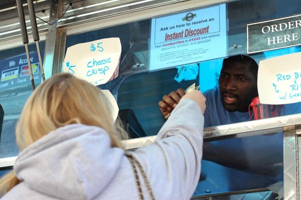 LOCAL CHOW: Food truck vendor Ray Pleasant takes orders from customers at the Food Truck Fiesta on Taylor Mall at the Downtown campus Tuesday. The food trucks were a kickoff event to spur interest in local businesses, sponsored by USG Downtown. (Photo by Lisa Bartoli)