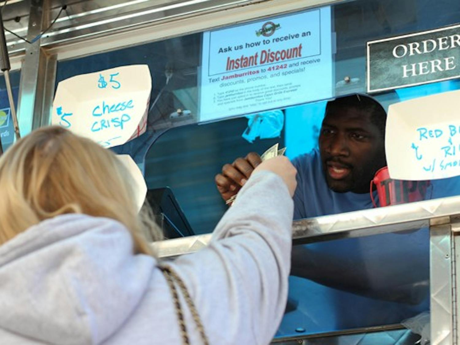 LOCAL CHOW: Food truck vendor Ray Pleasant takes orders from customers at the Food Truck Fiesta on Taylor Mall at the Downtown campus Tuesday. The food trucks were a kickoff event to spur interest in local businesses, sponsored by USG Downtown. (Photo by Lisa Bartoli)