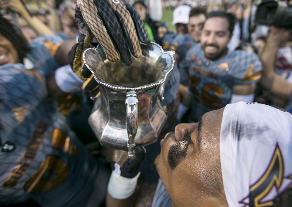 Players take turns kissing the Territorial Cup after winning a game against the Wildcats at Sun Devil Stadium in Tempe, Ariz., on Saturday, Nov. 21, 2015. The ASU Sun Devils took down the UA Wildcats, 52-36. 