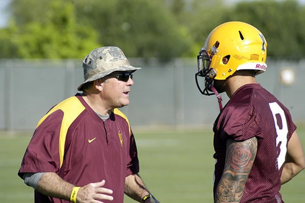 ASU football coach Todd Graham instructs senior wide receiver D.J. Foster during spring football practice in Tempe on March 17, 2015. (Fabian Ardaya/The State Press)