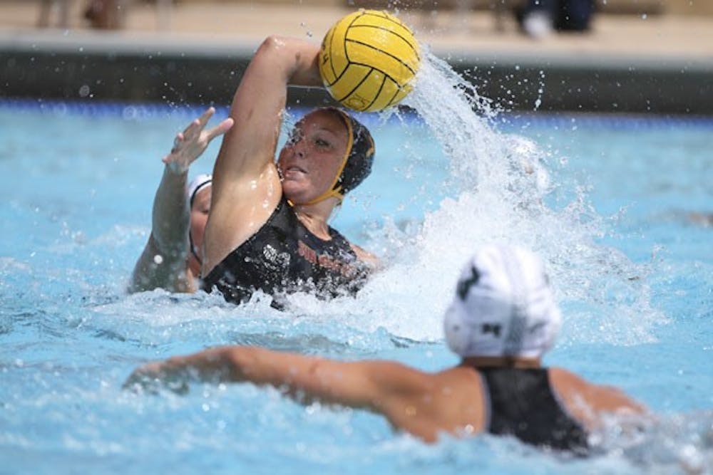 Senior center Shannon Haas palms the water polo ball to keep it out of reach of a Hawaii defender on April 4, 2012. Haas 
said the water polo team can make a statement by winning the UCSD Triton Invitational championship. (Photo by Samuel Rosenbaum)