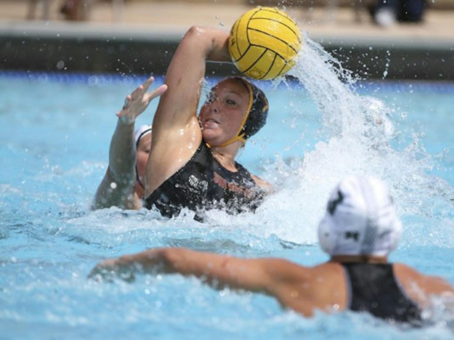 Senior center Shannon Haas palms the water polo ball to keep it out of reach of a Hawaii defender on April 4, 2012. Haas 
said the water polo team can make a statement by winning the UCSD Triton Invitational championship. (Photo by Samuel Rosenbaum)