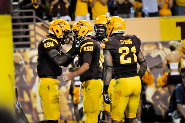 Junior running back D.J. Foster celebrates a touchdown with redshirt senior quarterback Taylor Kelly at the home game against Weber State on Aug. 28. (Photo by Andrew Ybanez)
