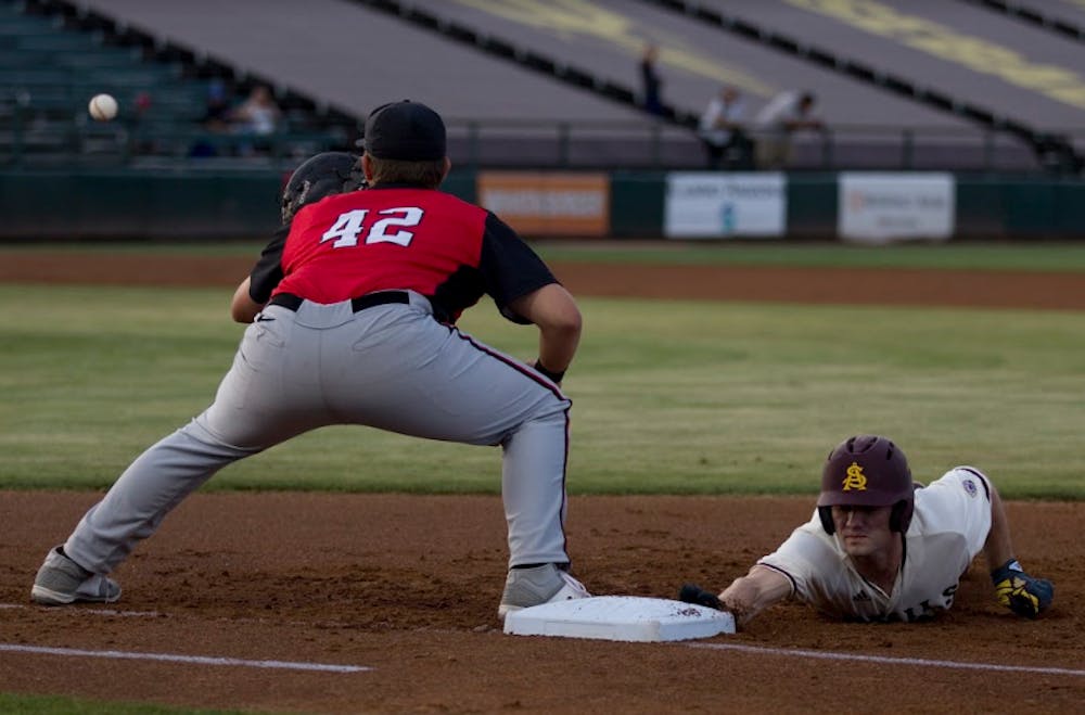 ASU sophomore outfielder Gage Canning (12) dives back safely to first base after a pick-off attempt during a baseball game against the UNLV Rebels at Phoenix Municipal Stadium in Phoenix, Arizona&nbsp;on Tuesday, April 11, 2017. ASU won 5-3.