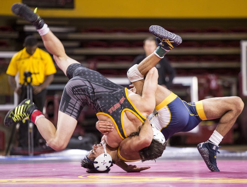 ASU's Robbie Mathers, left, flips around UNC's Sonny Espinoza in a 141-pound matchup during a meet against the University of Northern Colorado at Wells Fargo Arena in Tempe on Thursday, Nov. 12, 2015. The Sun Devils took down the UNC Bears 21-14.