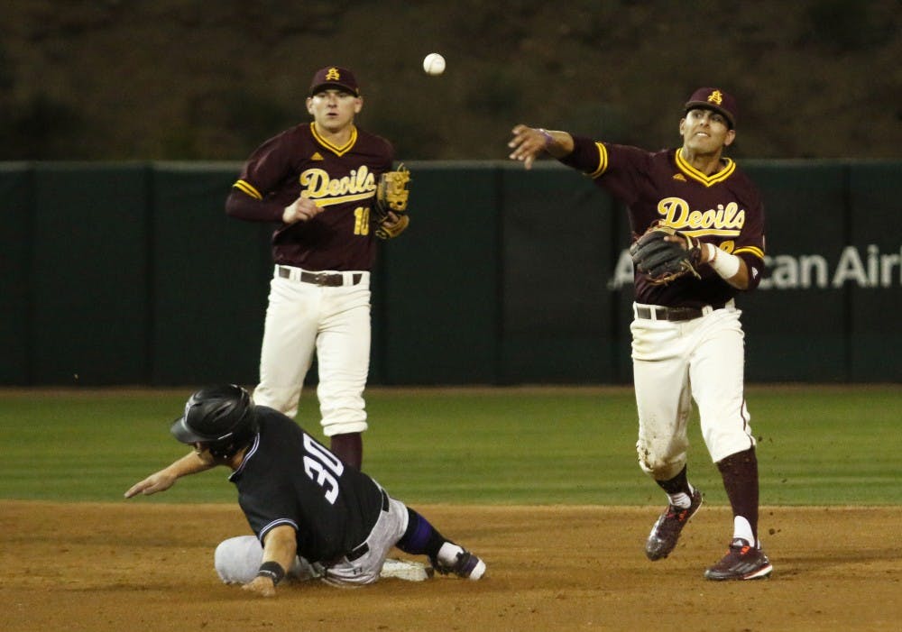 ASU freshman infielder Carter Aldrete (21) stops a Northwestern player on second base then throws the ball to first base in a baseball game against Northwestern at the Phoenix Municipal Stadium on Friday, Feb. 17, 2017. 