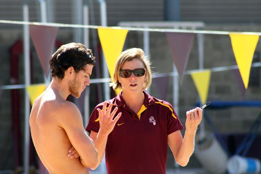 Coach Dorsey Tierney-Walker talks to junior diver Riley McCormick in a meet against UNLV on Oct. 22, 2011. Tierney-Walker is the driving force behind the resurgent swim teams. (Photo courtesy of Maggie Emmons)